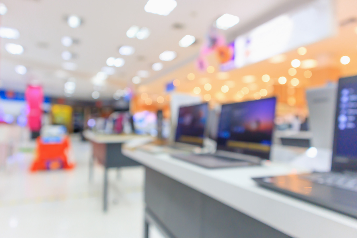 Computer notebook laptop on table at electronics store in shopping mall abstract blur defocused background