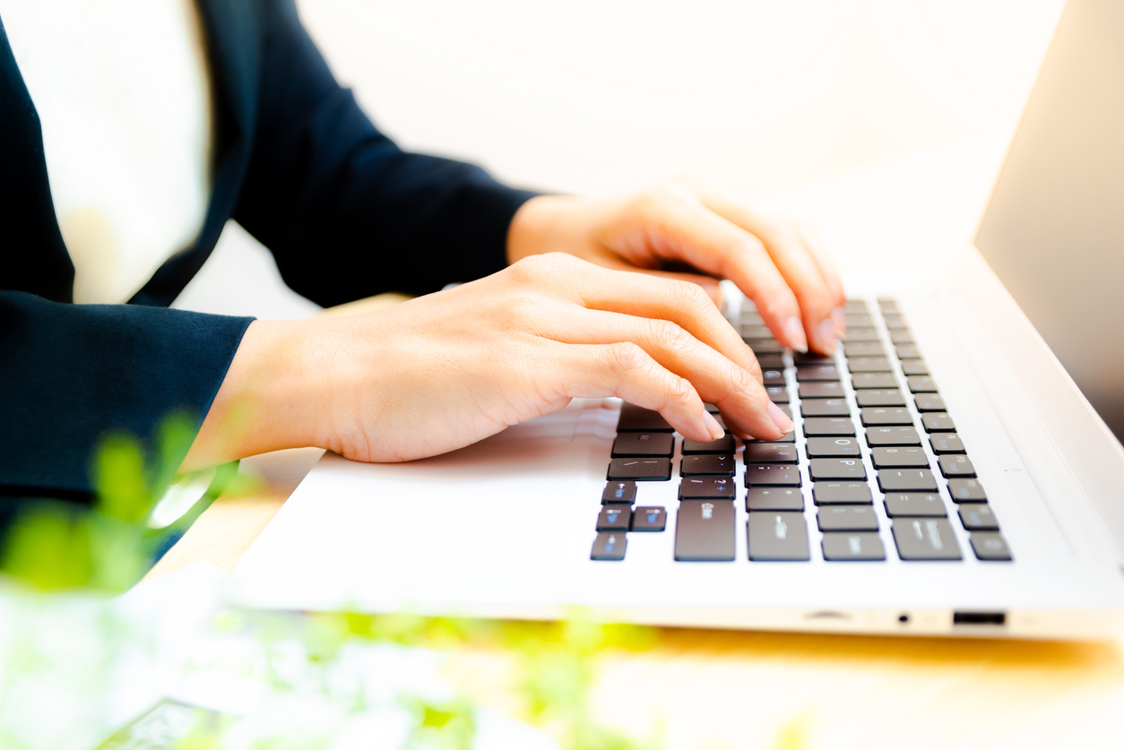 Closeup image of a business woman's hands working and typing on laptop keyboard